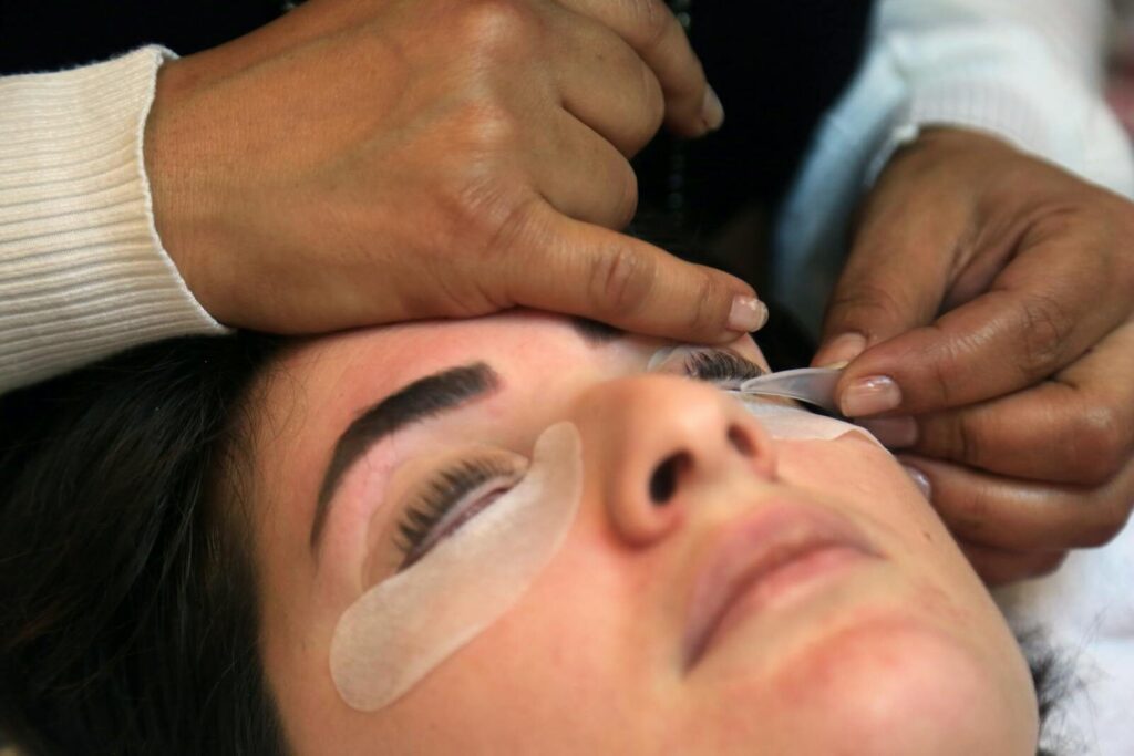 Close-up of a woman receiving an eyelash treatment in a spa setting, showcasing precision and care.