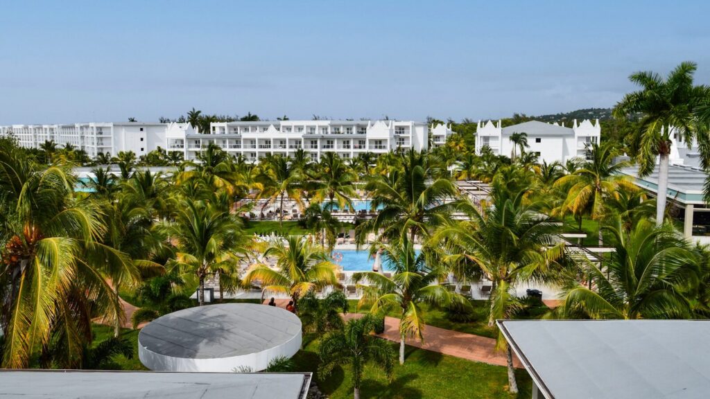 Tropical resort with palm trees and swimming pools.
