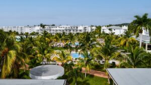 Tropical resort with palm trees and swimming pools.